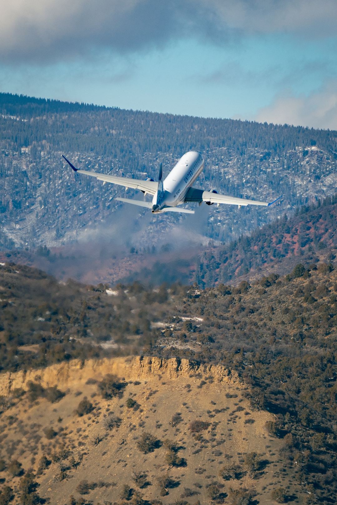 E175LR performing a quick climb out of Aspen airport for a short hop back to Denver