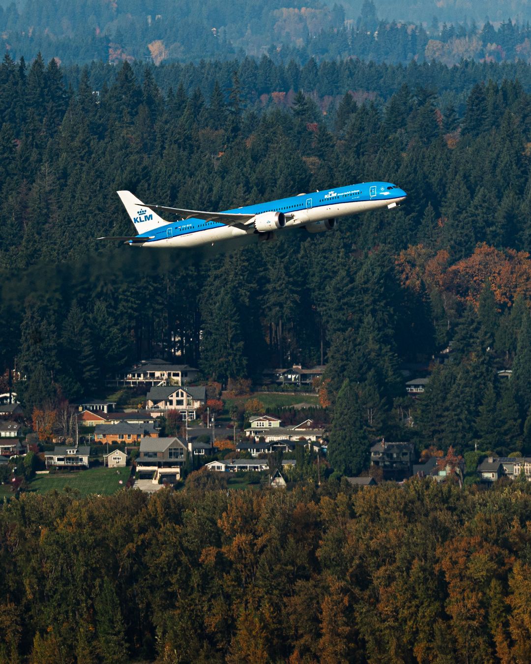 KLM 787 departs from PDX with a very green background 