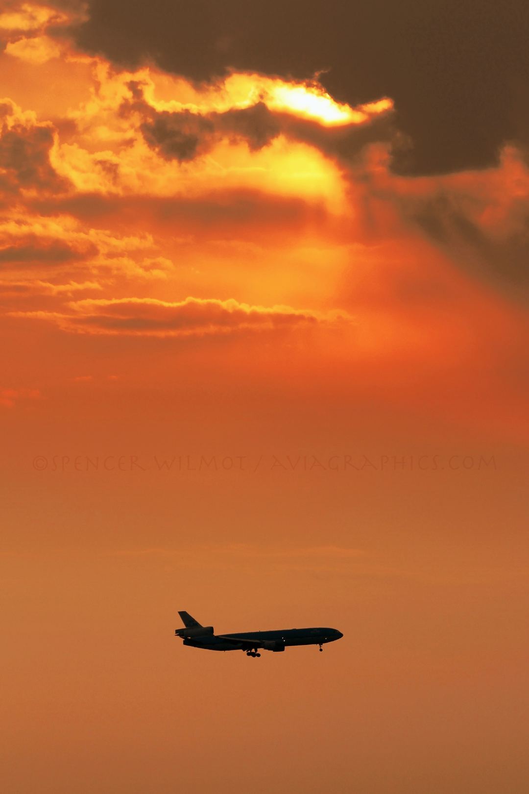 Filtered sunlight in various shades of reds and oranges as an MD-11 approaches Amsterdam.