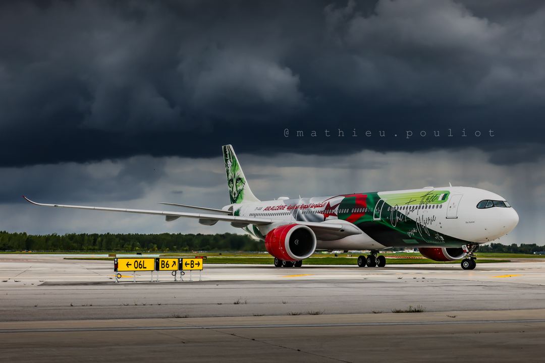 Air Algérie specially painted A330 “Fennec” makes its way onto the apron as a rainstorm moves in.