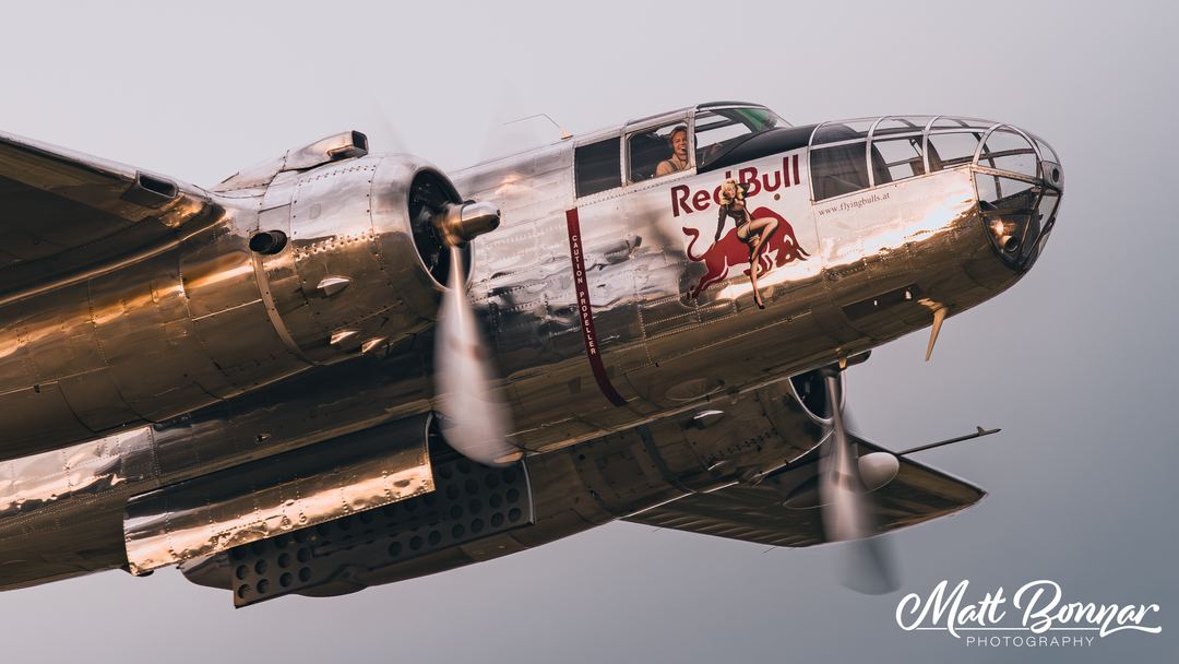 North American B-25J 'Mitchell', passing the crowd as the sun starts to set in the reflection.