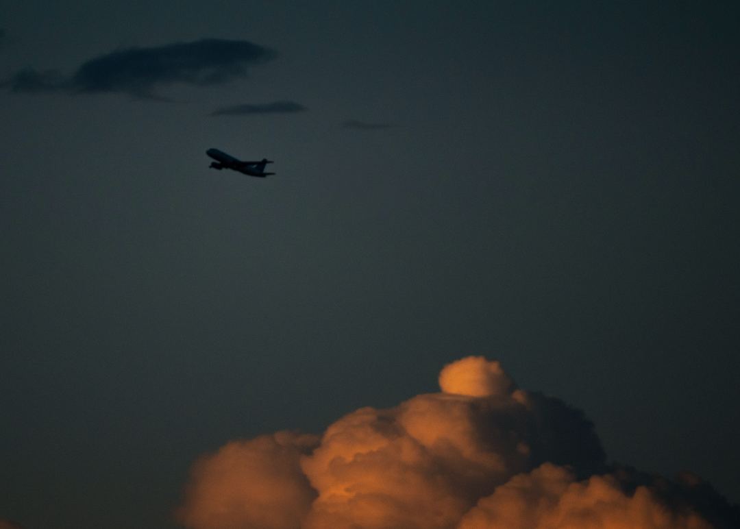 A320 departing Denver while towering clouds catch the last daylight